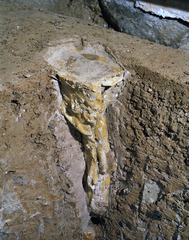 Detail of Object #17 in its clay matrix beneath the basement floor, undergoing excavation. This solid cone of beeswax was cast on site in The Grange basement. It contains a deer\'s shoulder bone, a human braid and woven fabric.,Iris Häussler